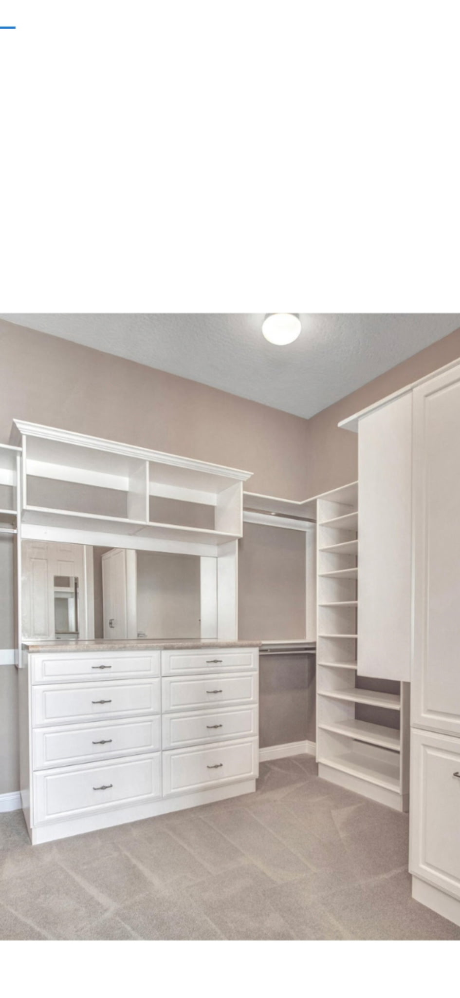 Custom walk-in closet with white built-in shelving and cabinetry