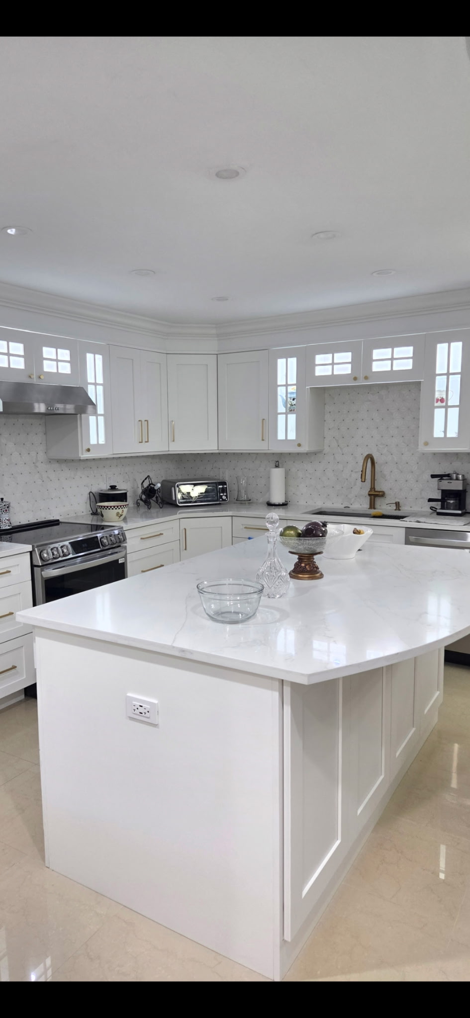 All-white kitchen with large island and premium appliances